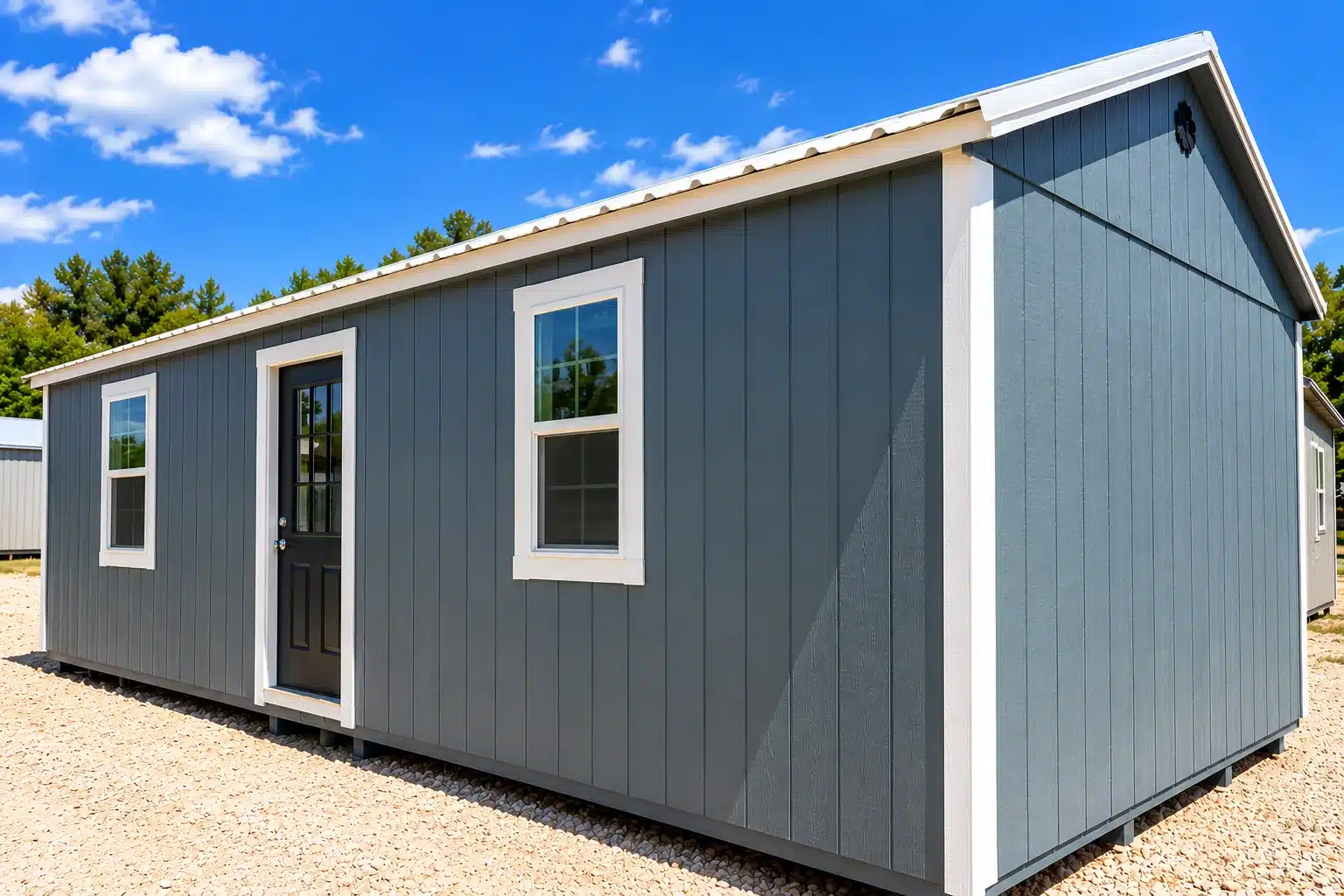 Real Secure Storage Sheds Pro Cottage in blue-gray siding with a black entry door and two windows